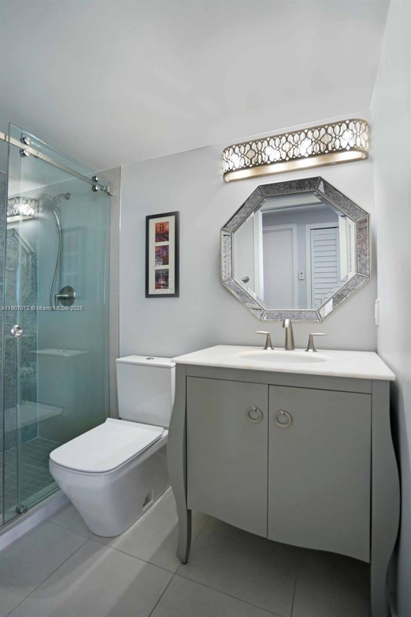 1621 Bay Road, Unit PH1 Miami Beach, FL 33139 - Photo 18 of 32 a bathroom with a sink mirror vanity and toilet