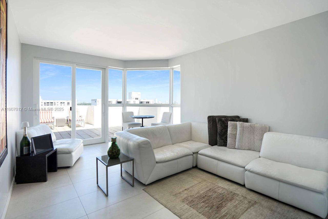 1621 Bay Road, Unit PH1 Miami Beach, FL 33139 - Photo 3 of 32 a living room with furniture and a large window