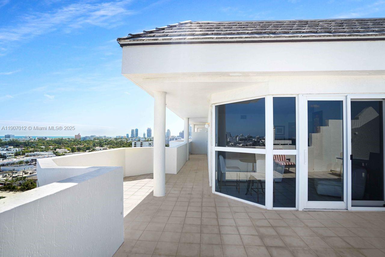 1621 Bay Road, Unit PH1 Miami Beach, FL 33139 - Photo 7 of 32 a view of a balcony with furniture and a floor to ceiling window