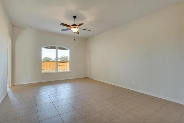 an empty room with a window and a fan