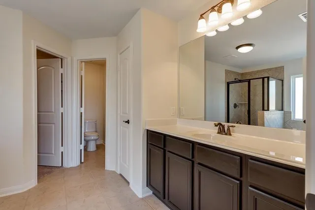 a bathroom with a double vanity sink a mirror and a shower