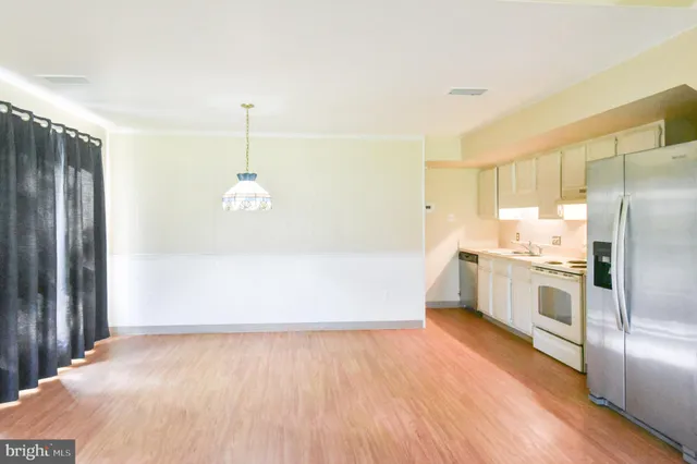 a kitchen with a refrigerator sink and cabinets