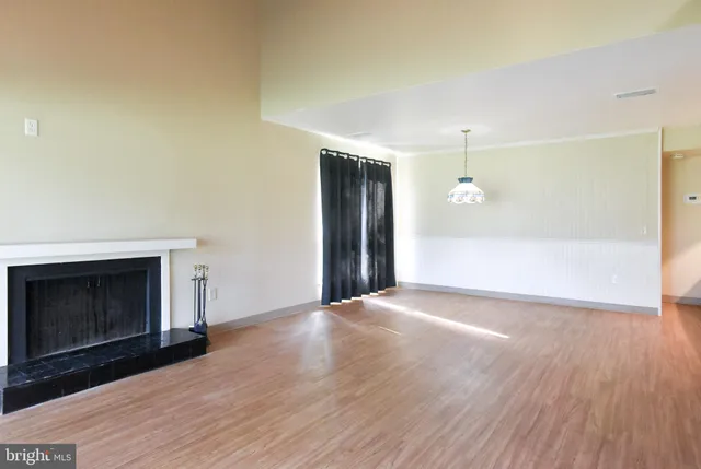 an empty room with windows and fireplace