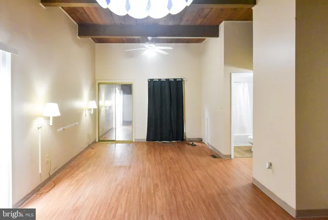 a view of empty room with wooden floor