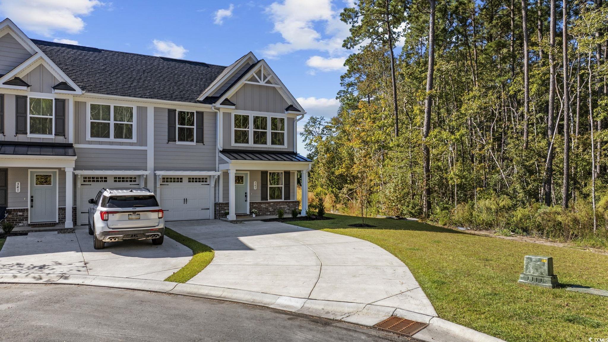 345 Bent Green, Unit 90A Murrells Inlet, SC 29576 - Photo 2 of 39 Craftsman house featuring a front yard, board and batten siding, a standing seam roof, concrete driveway, and a garage