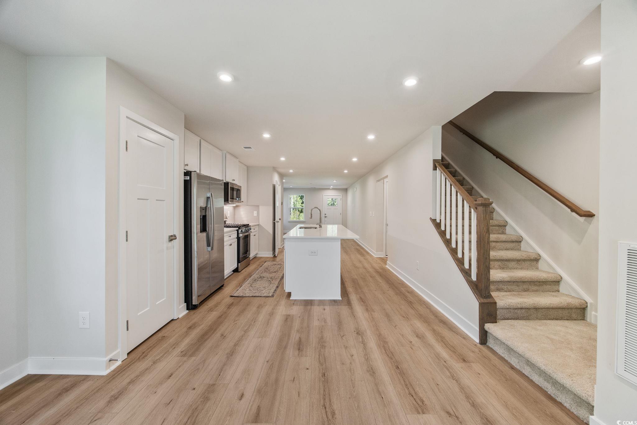 345 Bent Green, Unit 90A Murrells Inlet, SC 29576 - Photo 22 of 39 Kitchen with recessed lighting, an island with sink, white cabinetry, light wood-style flooring, and appliances with stainless steel finishes