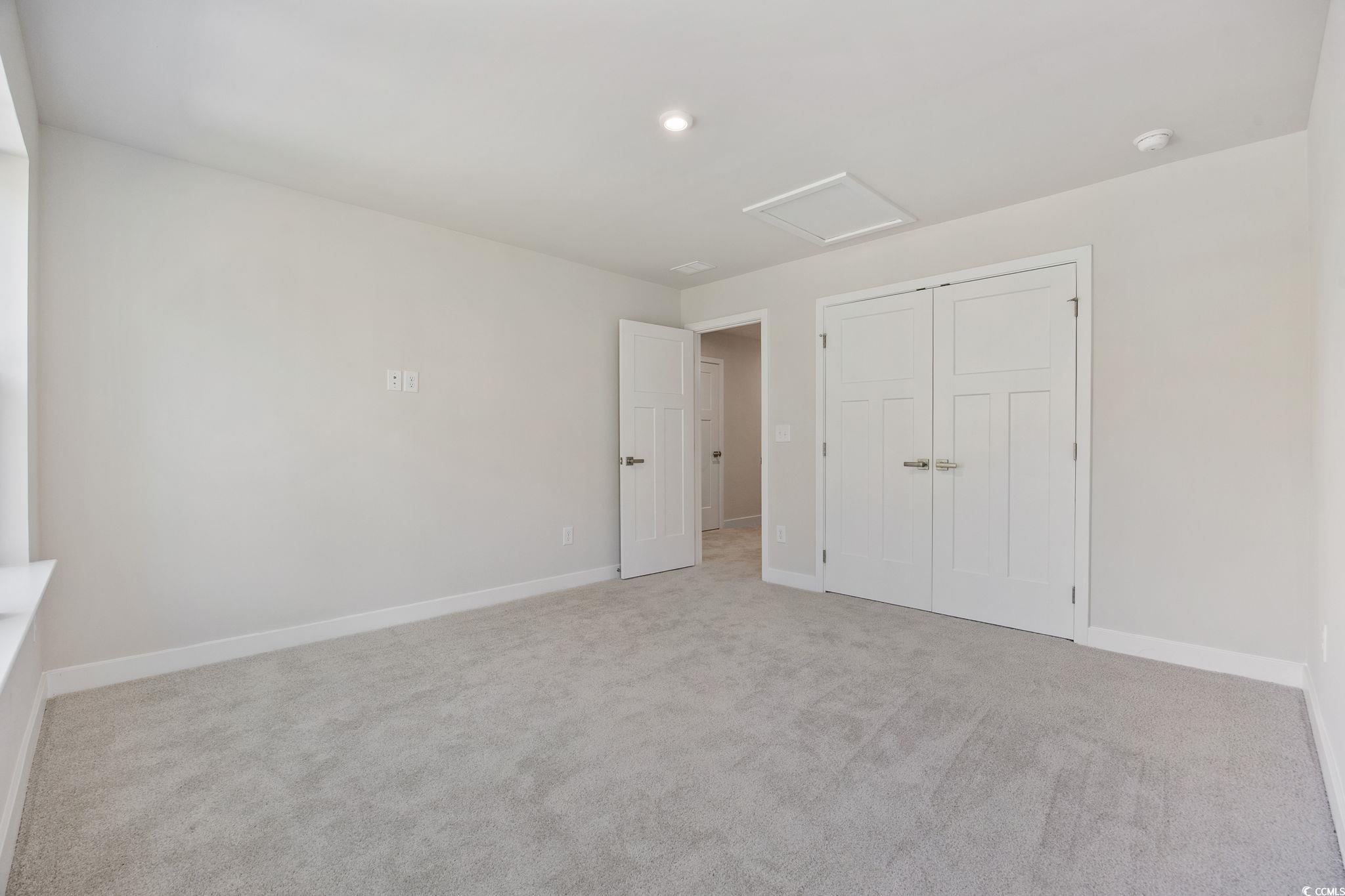 345 Bent Green, Unit 90A Murrells Inlet, SC 29576 - Photo 25 of 39 Unfurnished bedroom featuring attic access, light colored carpet, a closet, and recessed lighting