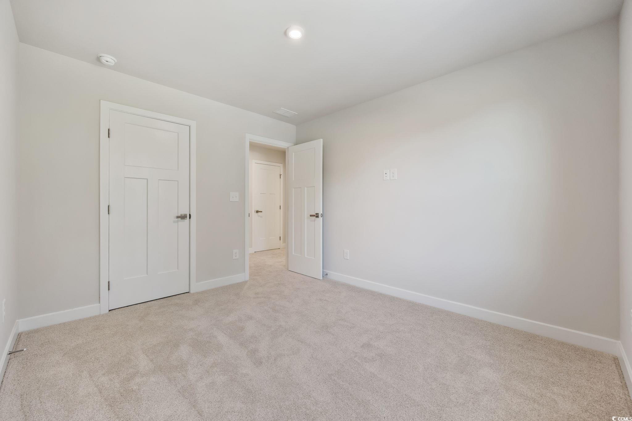 345 Bent Green, Unit 90A Murrells Inlet, SC 29576 - Photo 28 of 39 Unfurnished bedroom featuring baseboards and light carpet