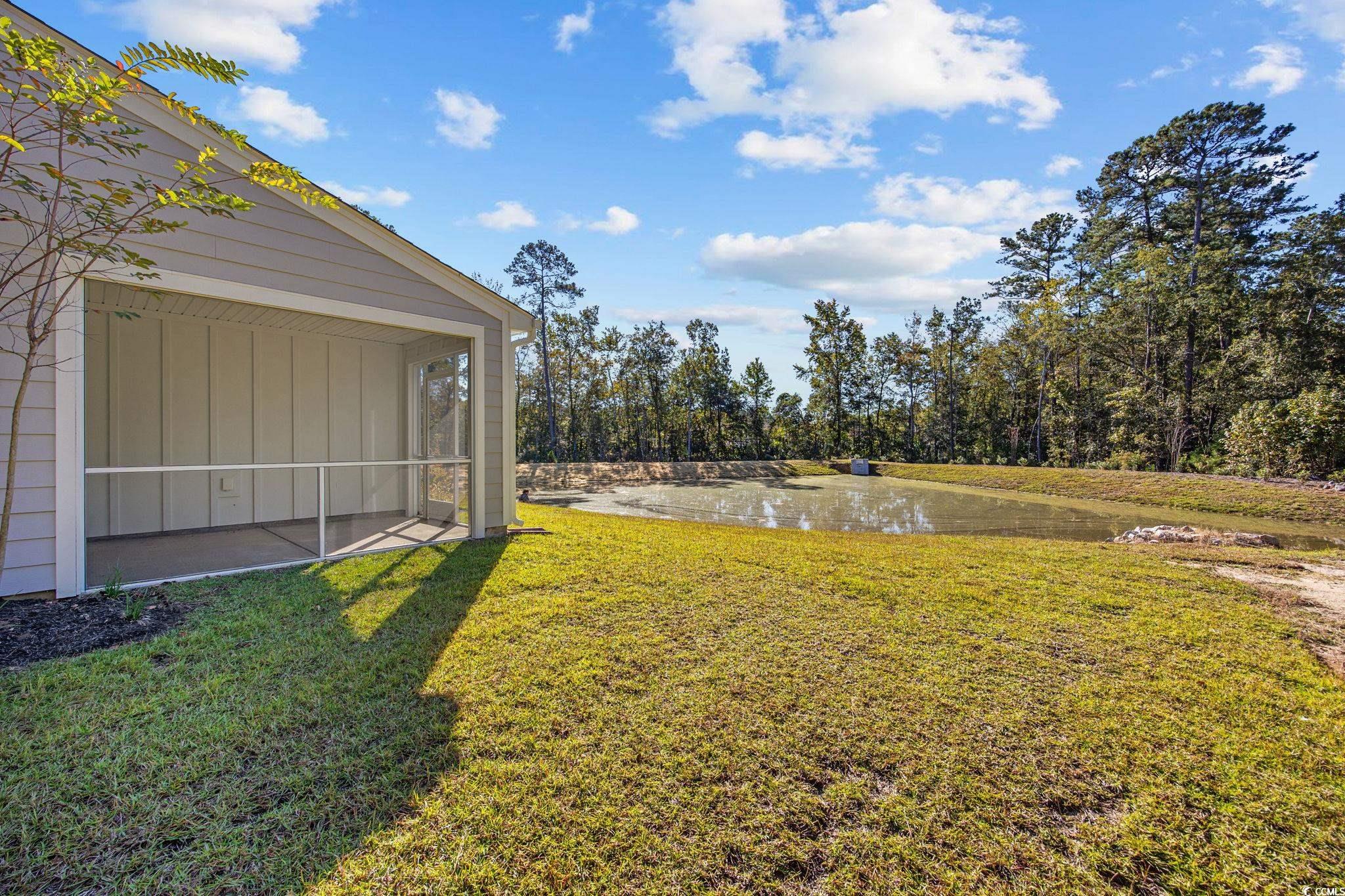 345 Bent Green, Unit 90A Murrells Inlet, SC 29576 - Photo 33 of 39 View of green lawn featuring a sunroom and a water view