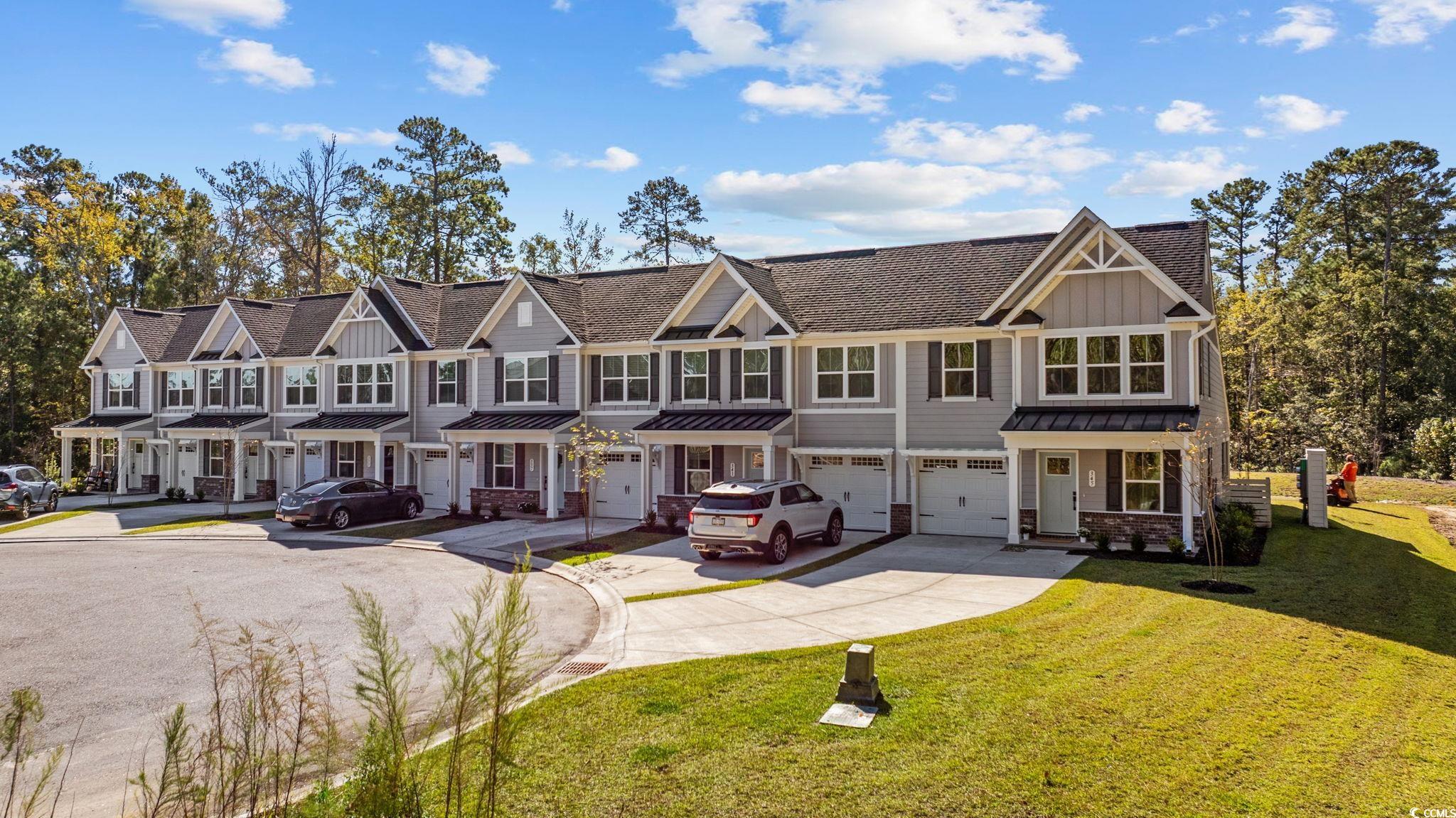 345 Bent Green, Unit 90A Murrells Inlet, SC 29576 - Photo 36 of 39 Craftsman-style home with board and batten siding, driveway, an attached garage, a front yard, and a standing seam roof