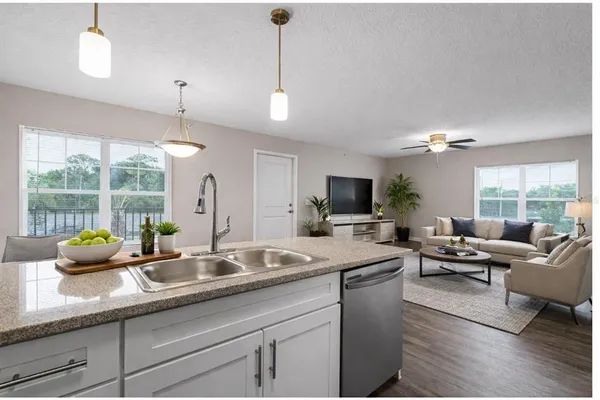 a kitchen with sink and living room view