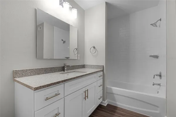 a bathroom with a granite countertop sink a toilet and shower