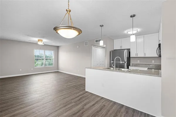 a kitchen with stainless steel appliances granite countertop a sink a stove a refrigerator and a window