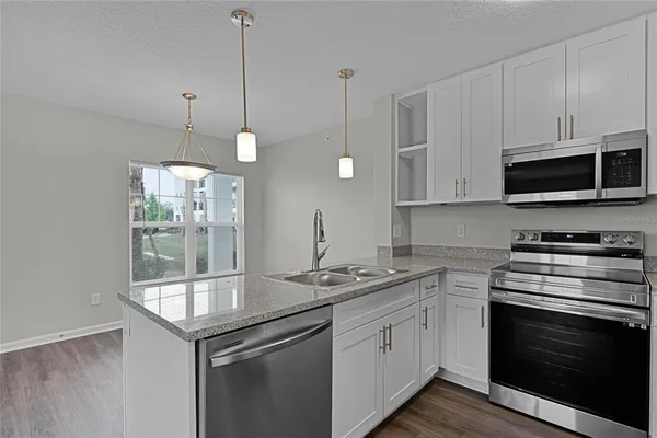 a kitchen with stainless steel appliances granite countertop a sink a stove and a microwave