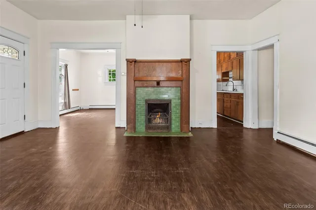 a view of an empty room with a fireplace and a window