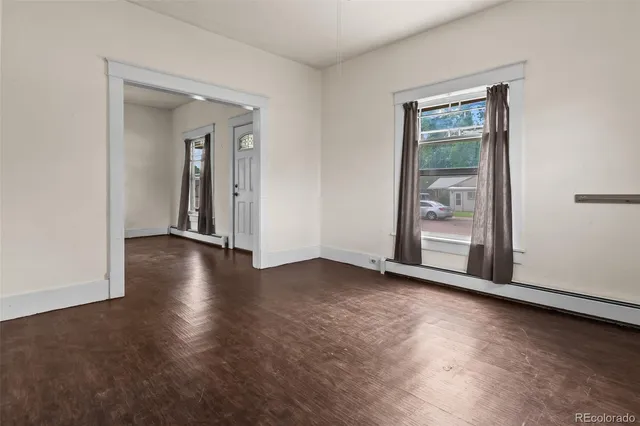 an empty room with wooden floor and a window