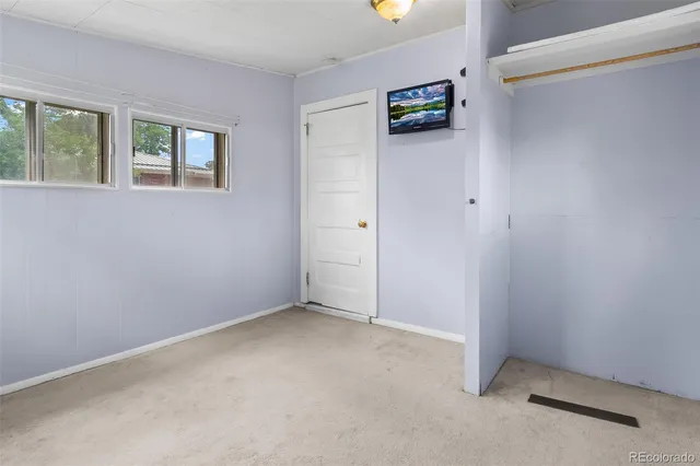 an empty room with windows and closet