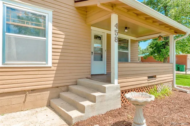 a view of a porch with a table and chairs next to a yard