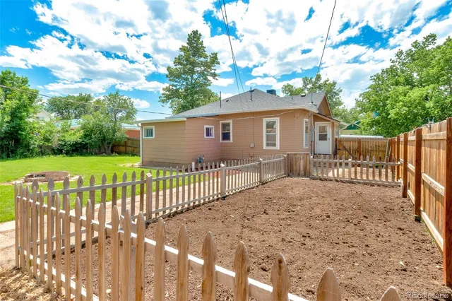 a view of a house with a wooden fence