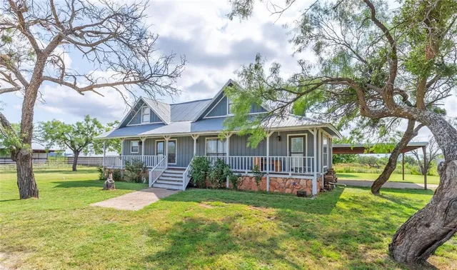 a front view of a house with a garden and trees