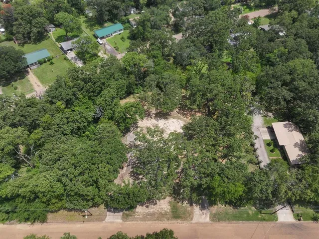 an aerial view of a house with a yard and trees