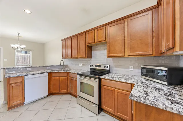 a kitchen with stainless steel appliances granite countertop a stove sink and cabinets
