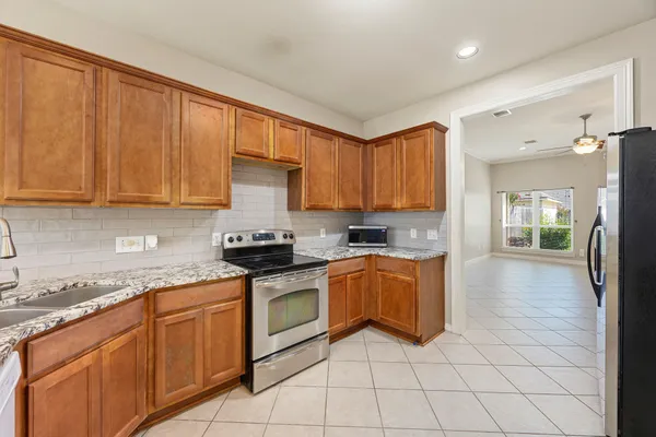 a kitchen with stainless steel appliances granite countertop a stove sink and cabinets