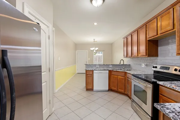 a kitchen with stainless steel appliances granite countertop a refrigerator and a sink