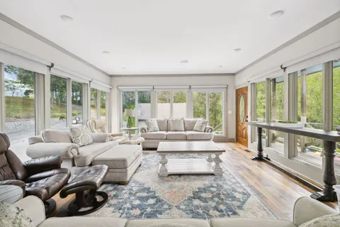 a living room with furniture a large window and gym equipment