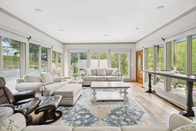 a living room with furniture a large window and gym equipment