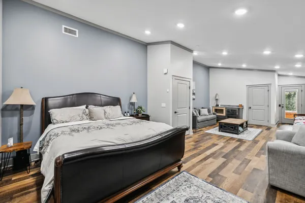 a bedroom with a bed and large windows
