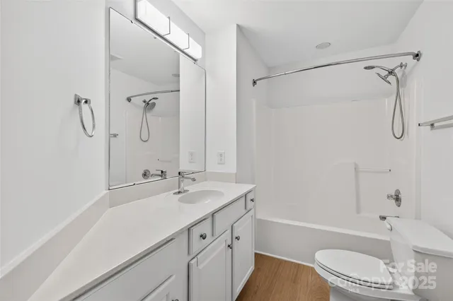 a bathroom with a granite countertop sink a toilet and shower
