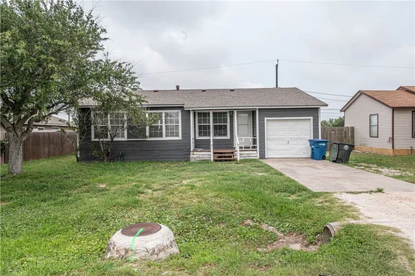 a front view of a house with a garden and yard
