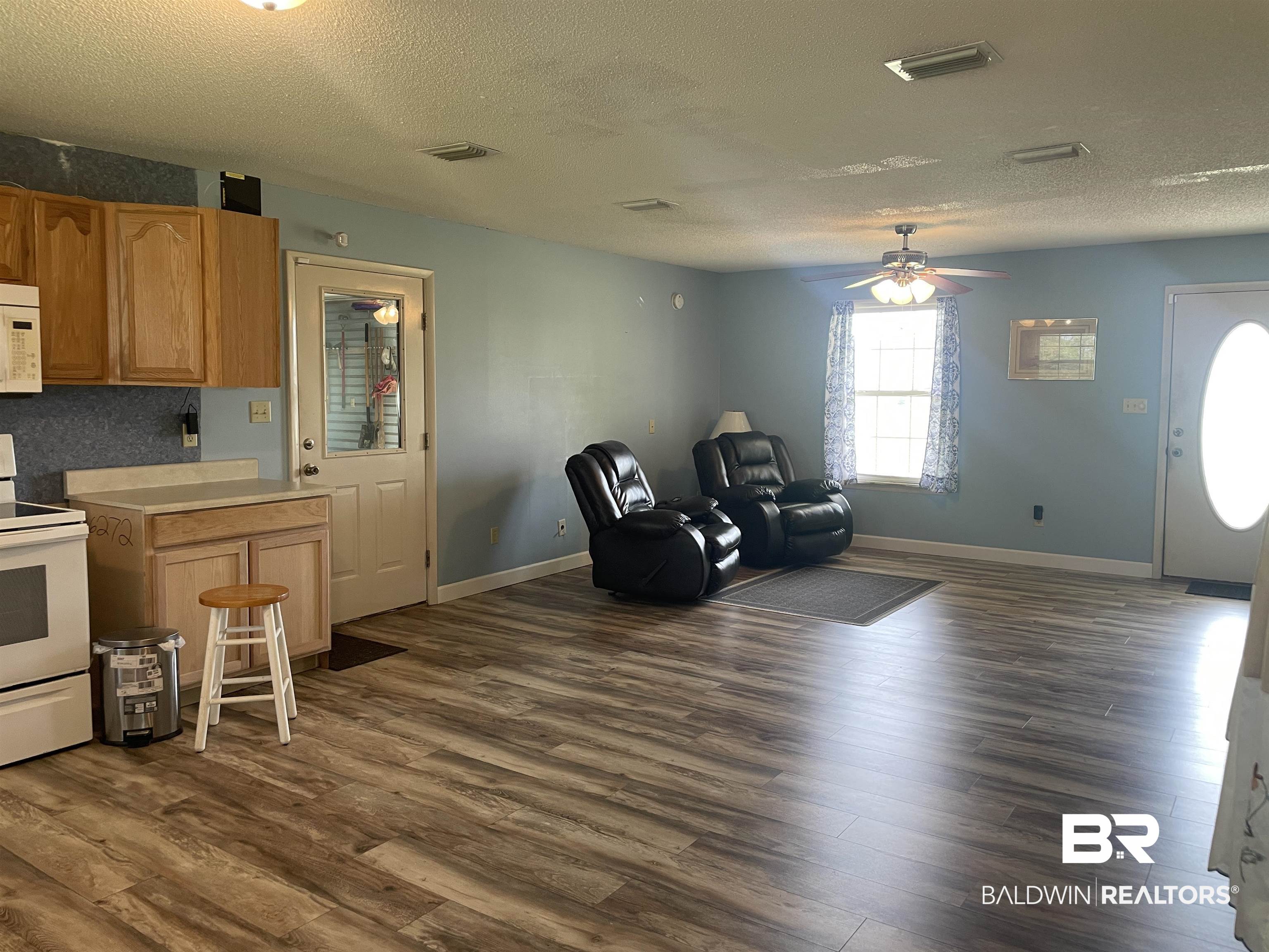 739 Smithfield Road Atmore, AL 36502 - Photo 5 of 18 Kitchen featuring light countertops, white appliances, dark wood-style floors, visible vents, and a ceiling fan
