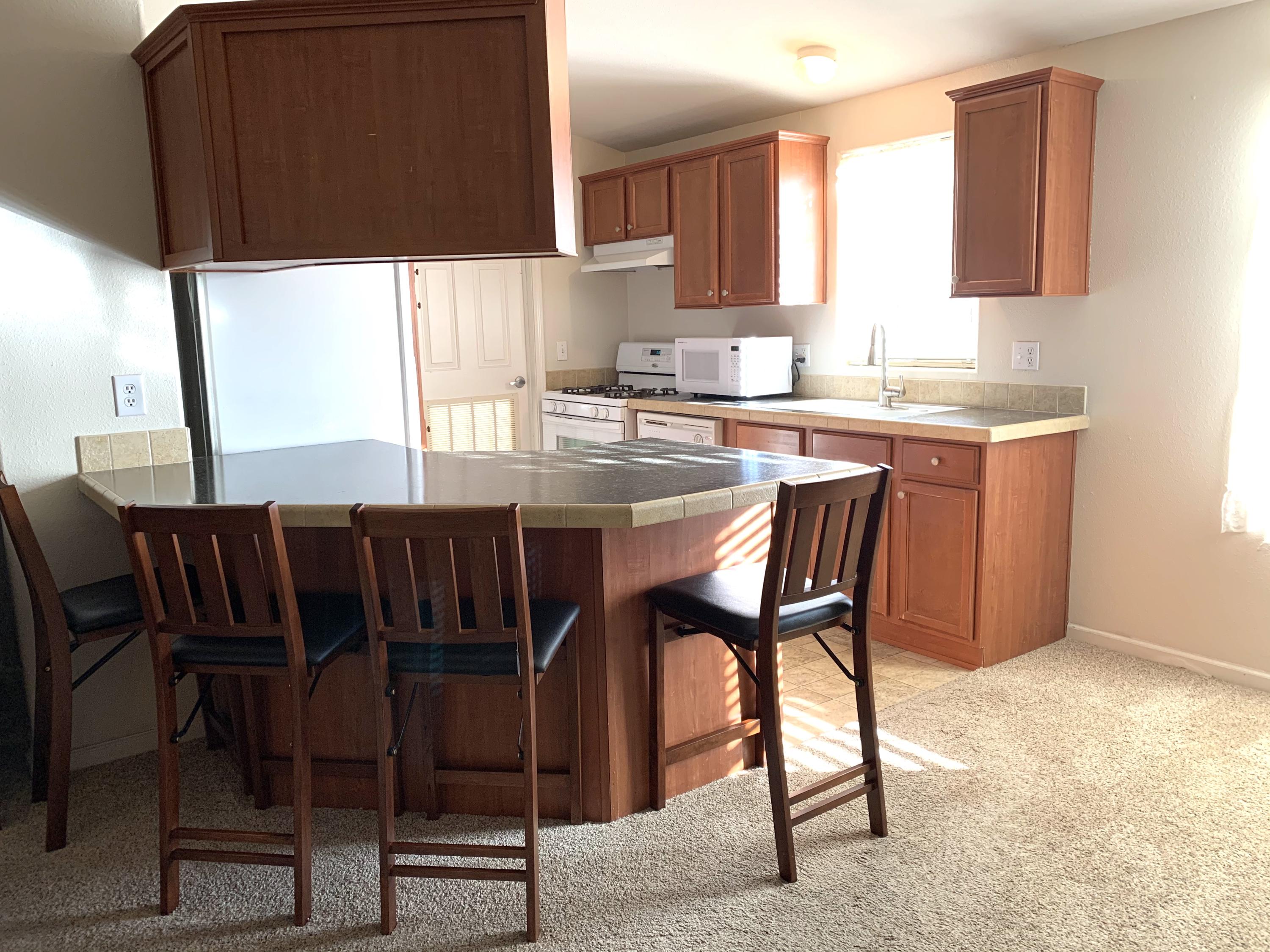 4935 Cedars Road Redding, CA 96001 - Photo 11 of 18 a kitchen with a dining table chairs and granite counter tops