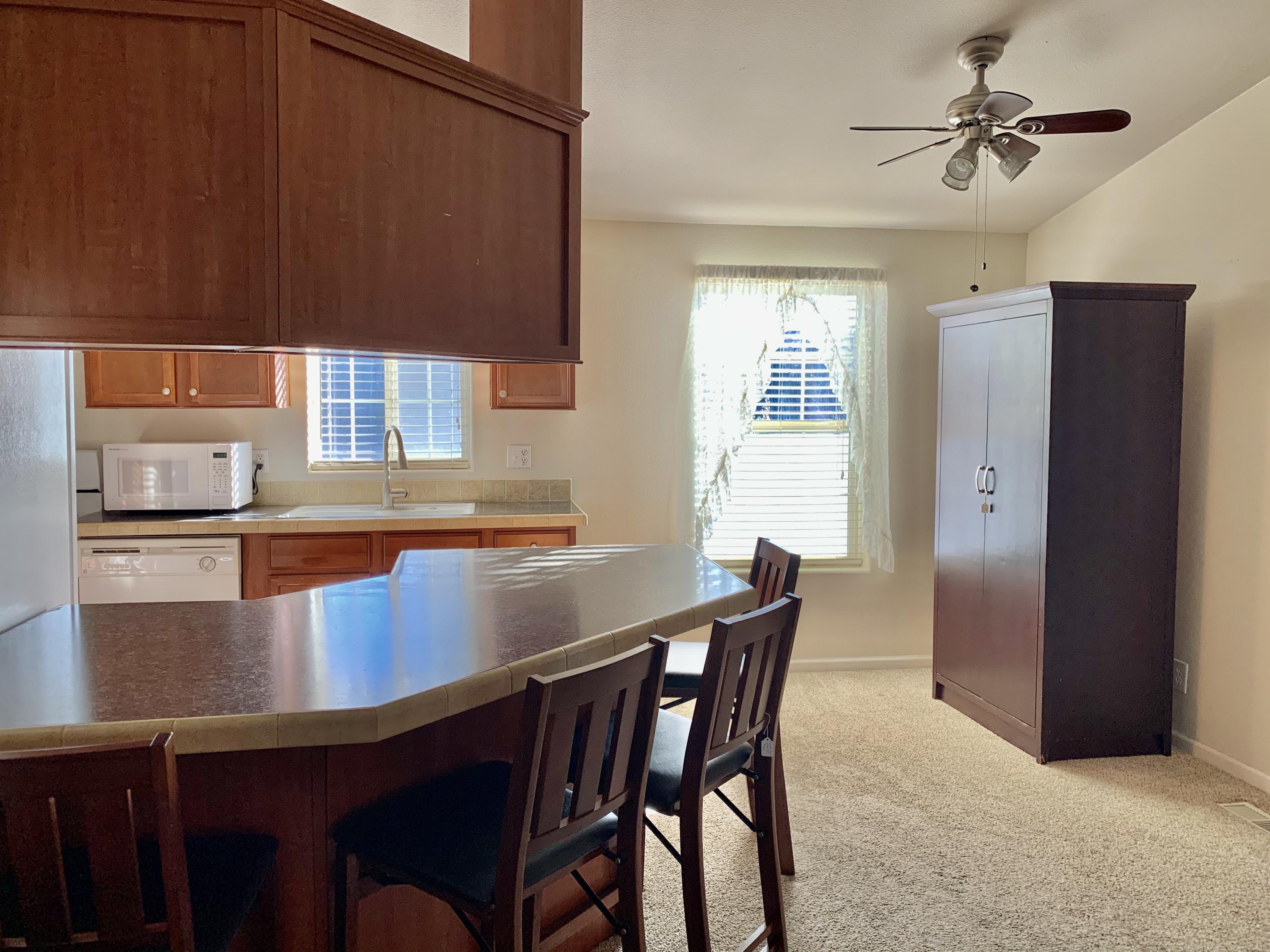 4935 Cedars Road Redding, CA 96001 - Photo 5 of 18 a kitchen with a table chairs sink and cabinets