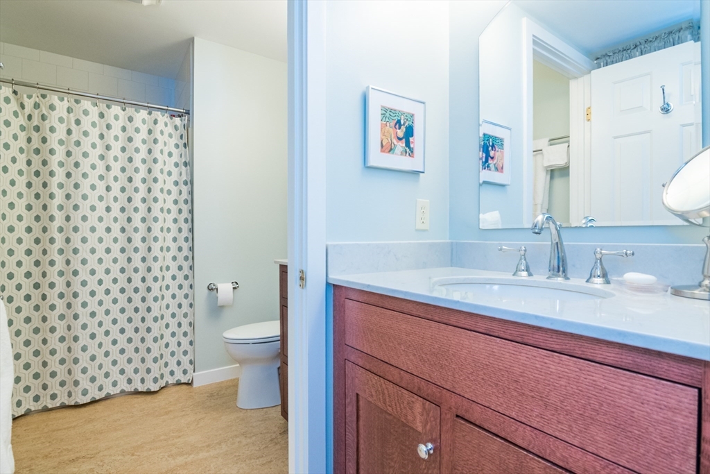 63 Amity Place, Unit 63 Amherst, MA 01002 - Photo 21 of 42 a bathroom with a granite countertop toilet sink and mirror
