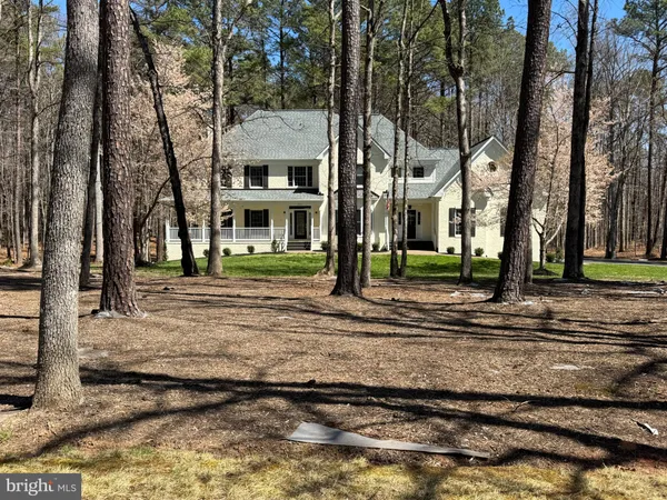 a view of a house with a yard and tree s