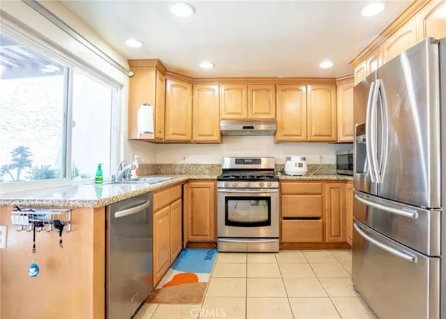 a kitchen with stainless steel appliances granite countertop a refrigerator and a stove