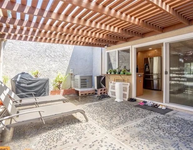 a backyard of a house with barbeque oven table and chairs
