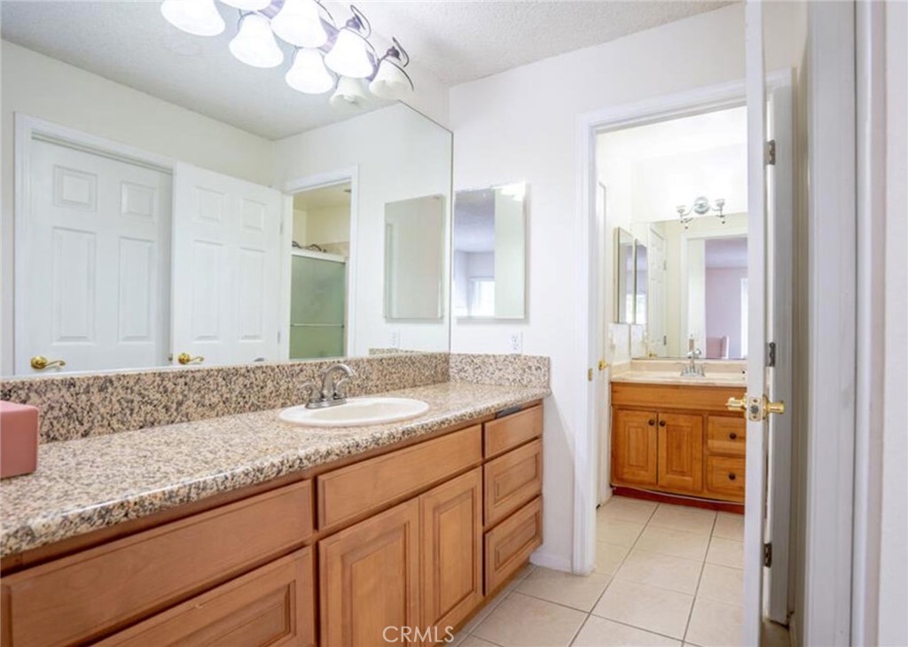 16520 Poppyglen Lane Cerritos, CA 90703 - Photo 5 of 17 a bathroom with a granite countertop sink and a mirror
