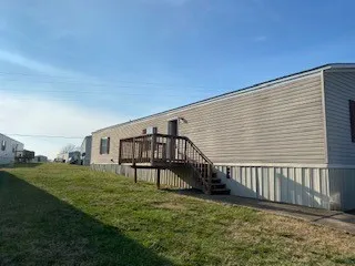 a view of a house with wooden deck and a big yard