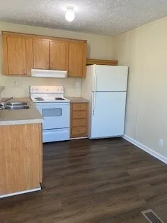 a kitchen with a refrigerator stove and wooden cabinets
