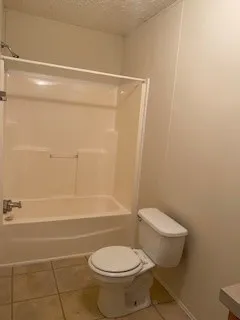 a white toilet sitting next to a bath tub
