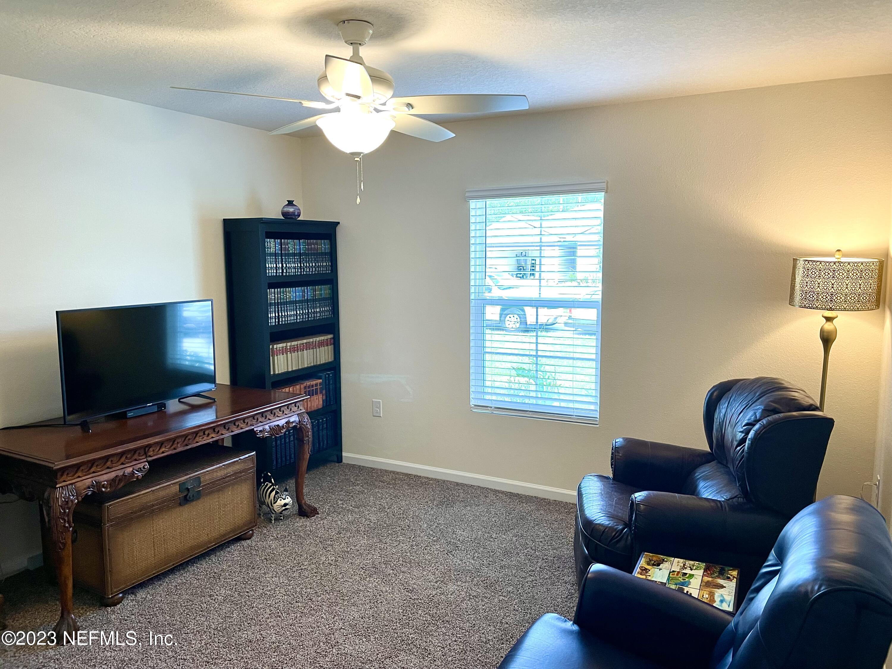 115 Falcon Ridge Road St. Augustine, FL 32084 - Photo 17 of 27 a living room with furniture and a flat screen tv