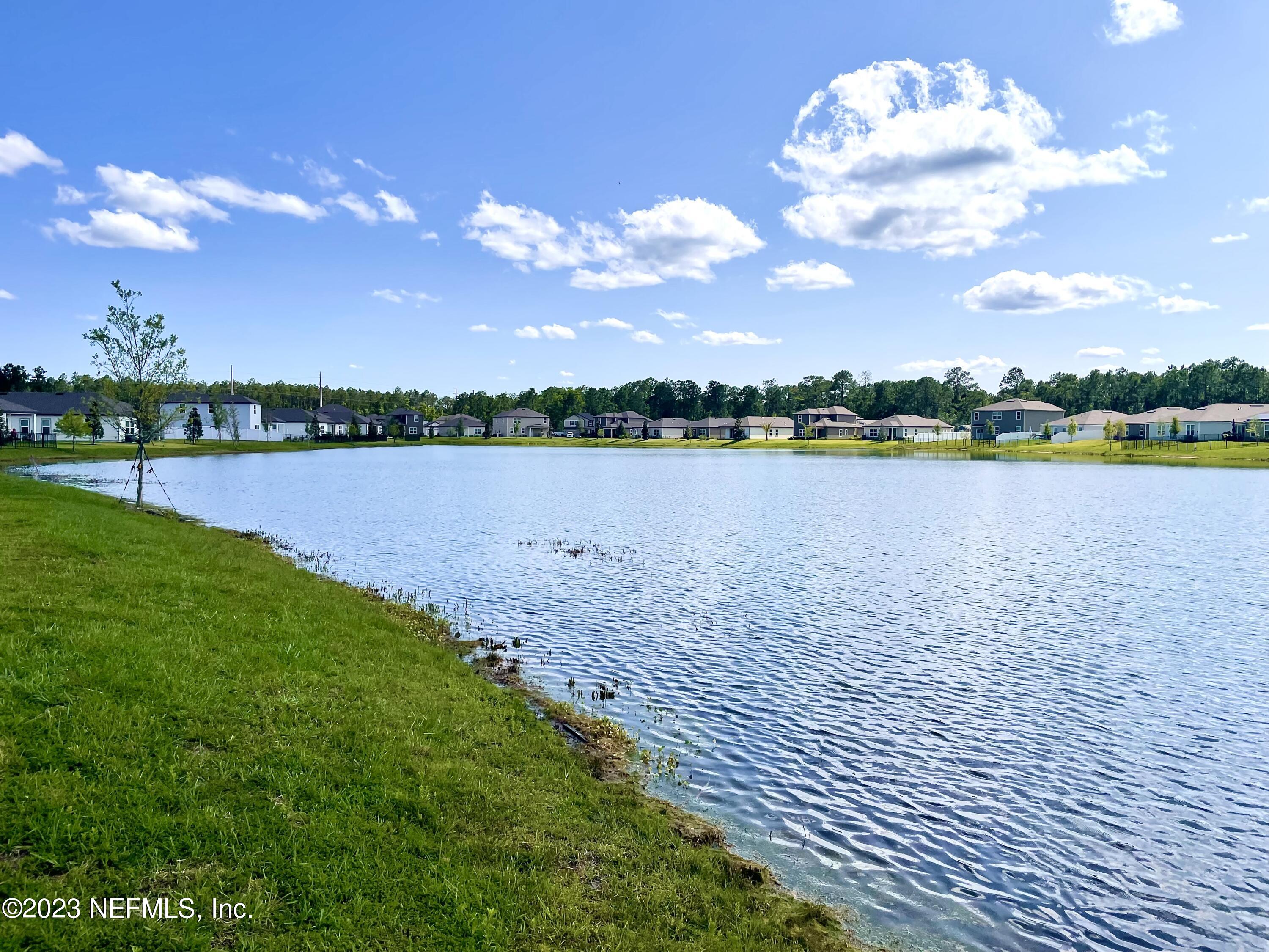 115 Falcon Ridge Road St. Augustine, FL 32084 - Photo 25 of 27 a view of a lake with houses in the back
