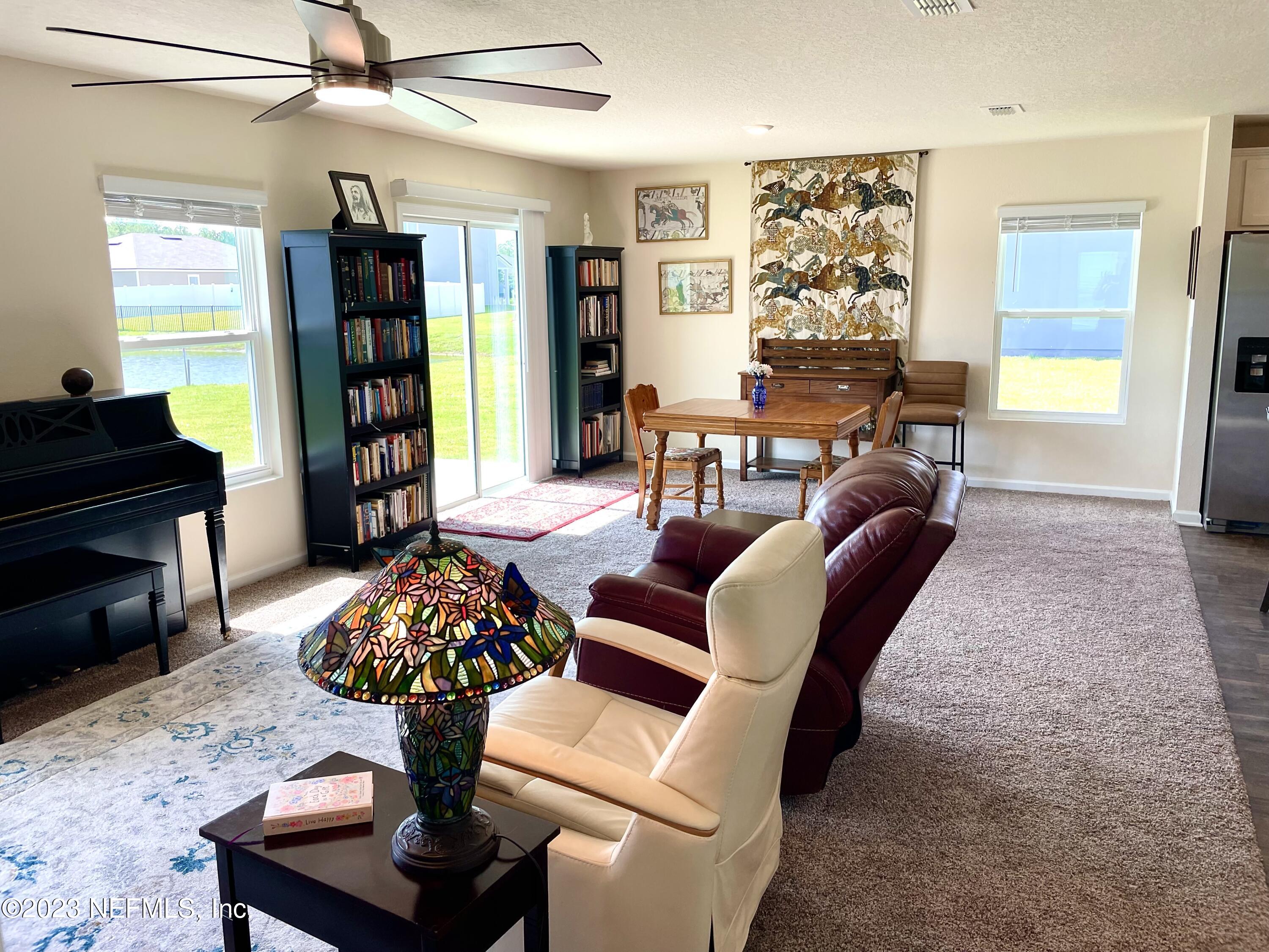 115 Falcon Ridge Road St. Augustine, FL 32084 - Photo 3 of 27 a living room with furniture and a fireplace
