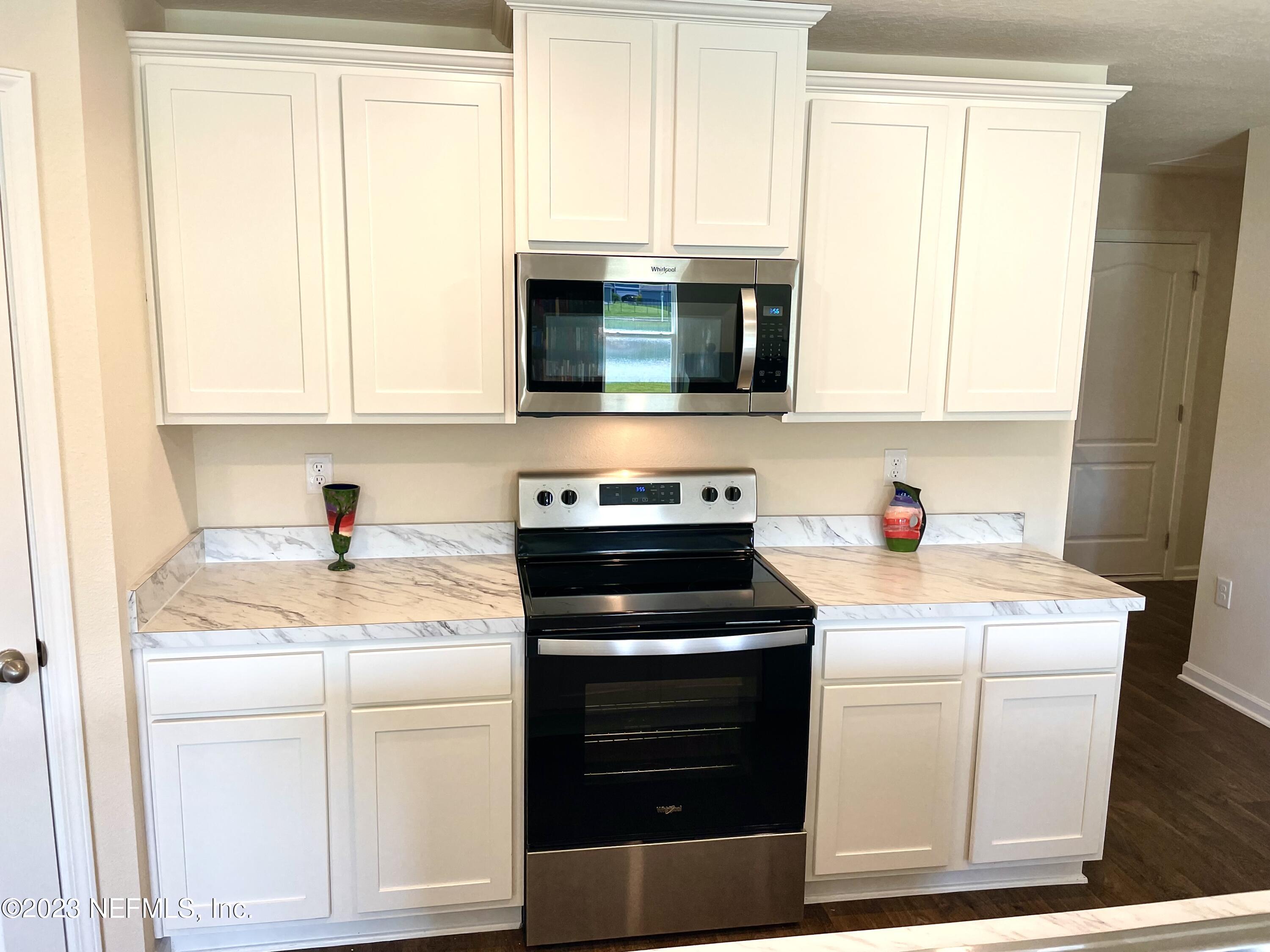 115 Falcon Ridge Road St. Augustine, FL 32084 - Photo 8 of 27 a kitchen with granite countertop white cabinets and white appliances