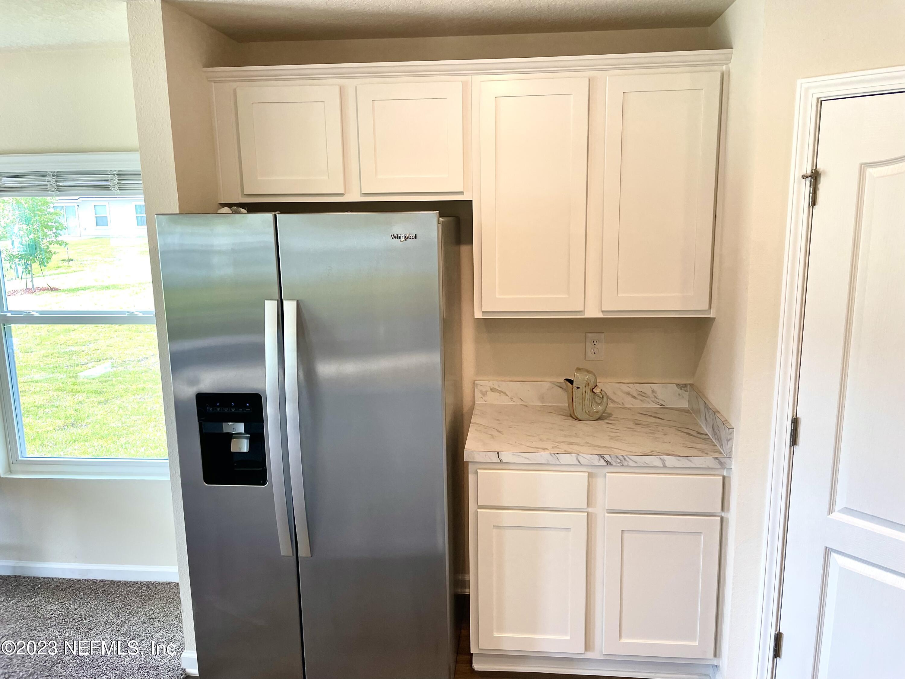 115 Falcon Ridge Road St. Augustine, FL 32084 - Photo 9 of 27 a bathroom with a granite countertop sink and a refrigerator