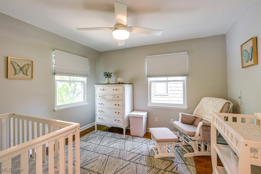 2340 Canterbury Road University Heights, OH 44118 - Photo 19 of 29 Bedroom featuring baseboards, wood finished floors, a nursery area, and multiple windows